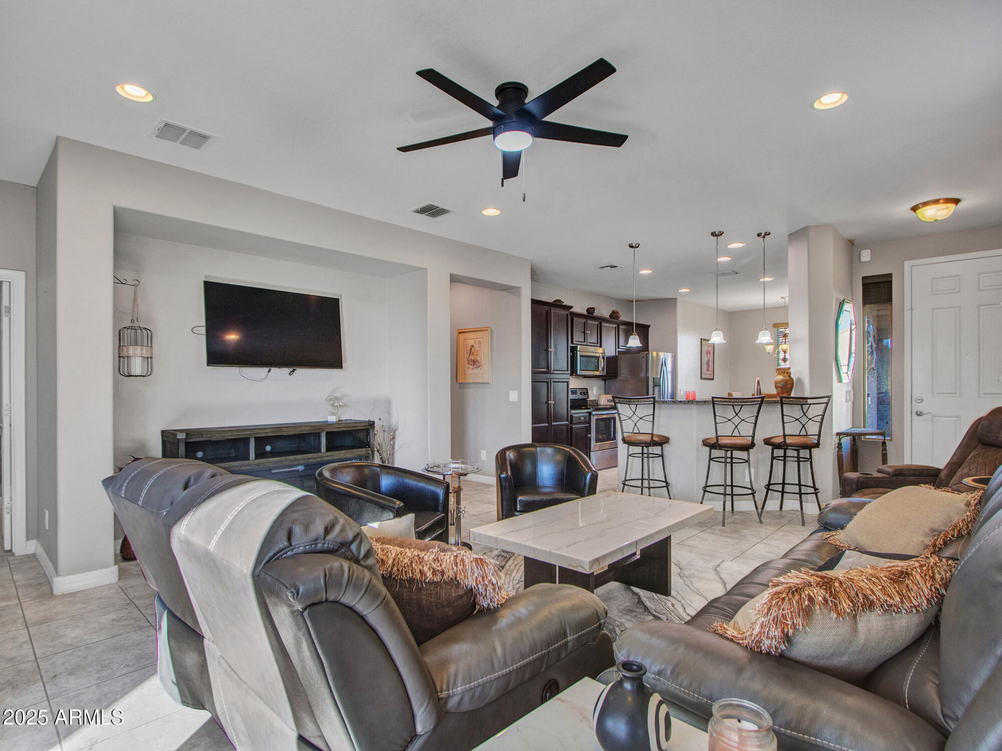 22585 West Moonlight Path Buckeye, AZ 85326 - Photo 9 of 35 a living room with furniture kitchen view and a flat screen tv