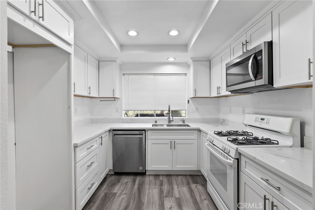 4 Gettysburg Irvine, CA 92620 - Photo 16 of 48 a kitchen with stainless steel appliances granite countertop a sink stove a microwave and cabinets
