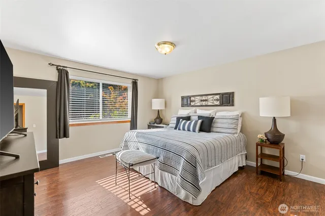 a bedroom with a bed and wooden floor