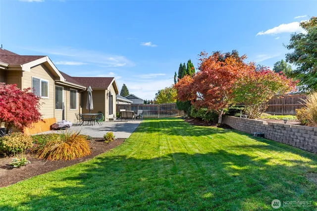a view of a house with a big yard potted plants and large tree