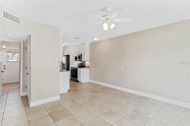 an empty room with kitchen view