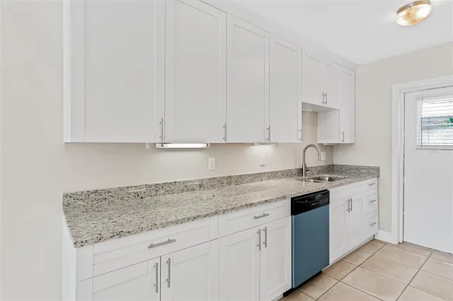 a kitchen with granite countertop white cabinets and white appliances