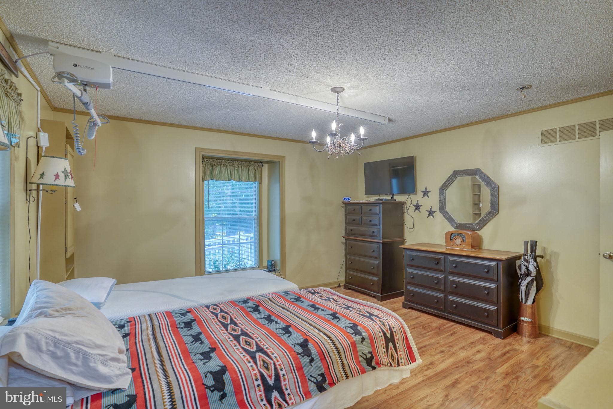 1332 Alley Mill Road Clayton, DE 19938 - Photo 29 of 50 a bedroom with a bed and a chandelier