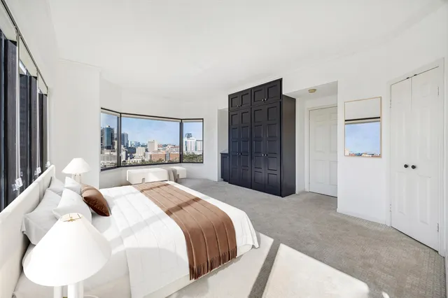 a large bedroom with a bed and a refrigerator