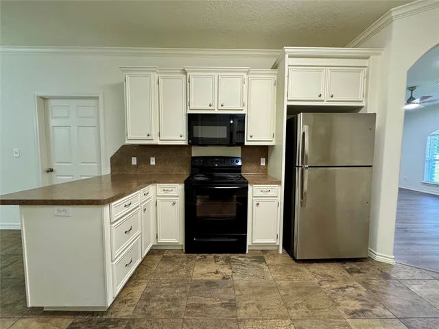 a kitchen with granite countertop a refrigerator and a stove