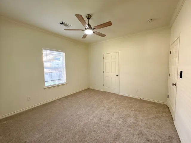 an empty room with a window and a fan