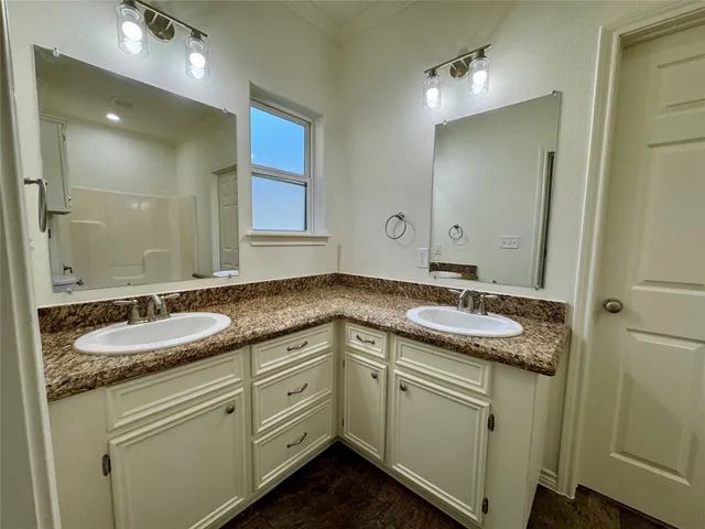 a bathroom with a granite countertop sink double and mirror