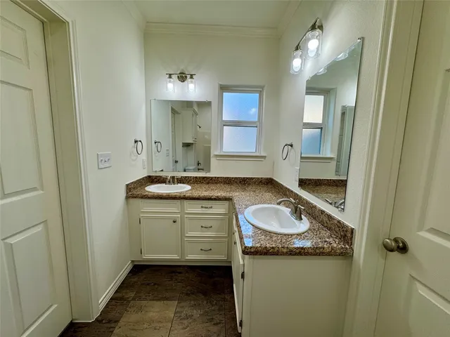 a bathroom with a granite countertop sink and a mirror