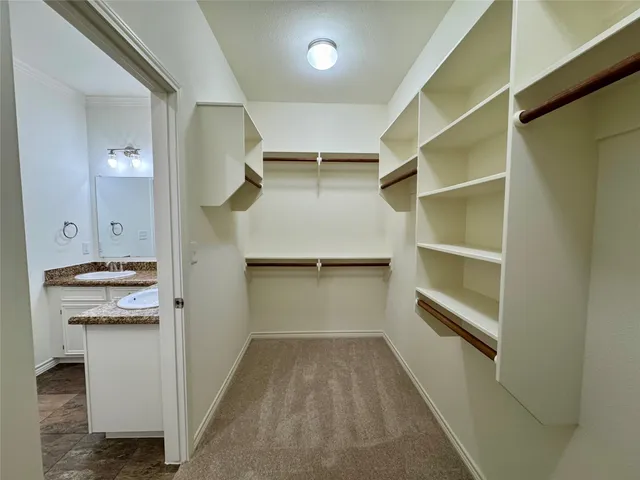 a view of walk in closet with empty racks