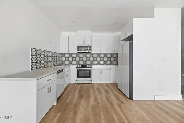 a kitchen with white cabinets and white appliances