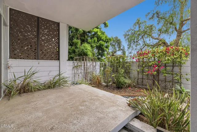 a view of a terrace with lawn chairs