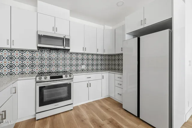 a kitchen with white cabinets and white appliances