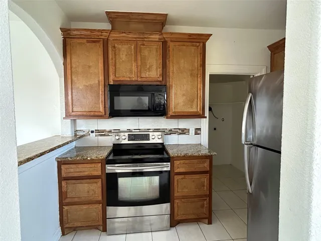 a kitchen with stainless steel appliances a stove a microwave and a refrigerator