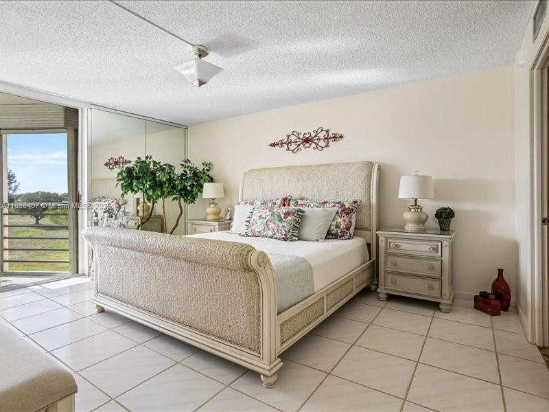 6200 Northwest 2nd Avenue, Unit 418 Boca Raton, FL 33487 - Photo 11 of 41 a spacious bedroom with a bed and a chandelier