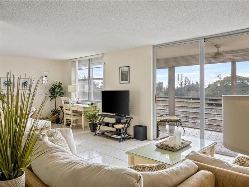 6200 Northwest 2nd Avenue, Unit 418 Boca Raton, FL 33487 - Photo 24 of 41 a living room with furniture a flat screen tv and a large window