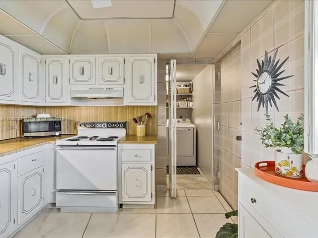 a kitchen with white cabinets and white appliances