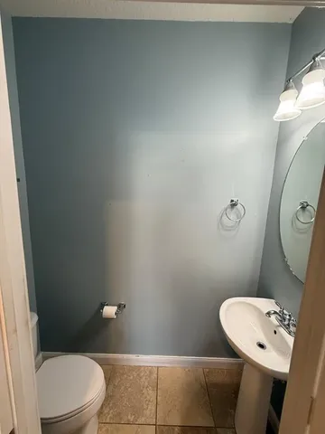 a white toilet sitting next to a bathroom sink