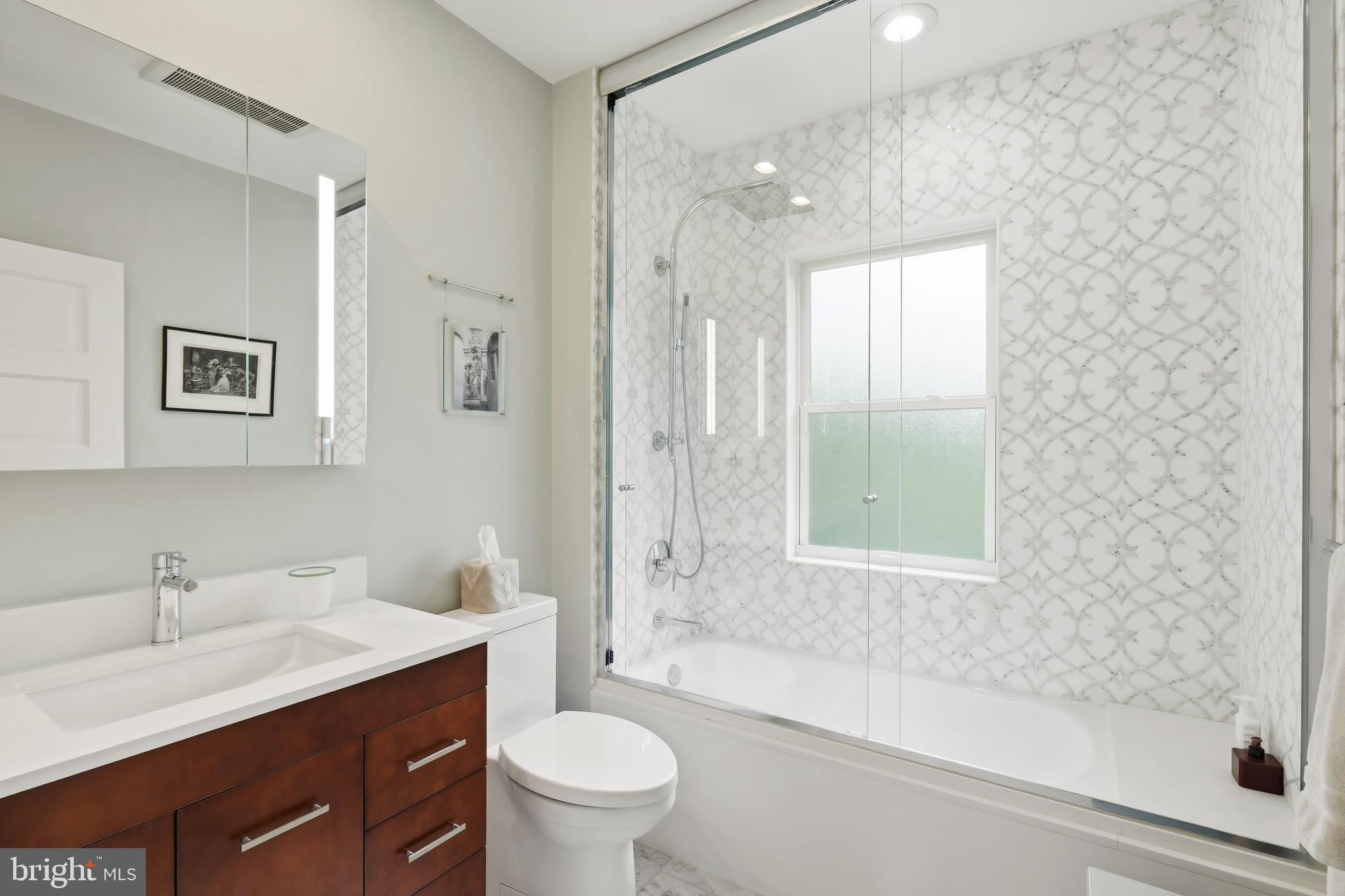 6411 33rd Street Northwest Washington, DC 20015 - Photo 34 of 48 a bathroom with a bathtub shower sink vanity mirror and toilet