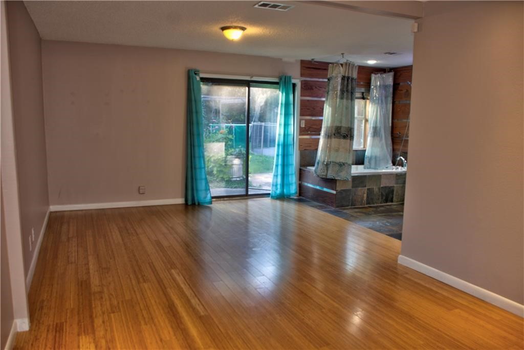 7000 Greenock Street Austin, TX 78749 - Photo 13 of 22 an empty room with wooden floor and windows