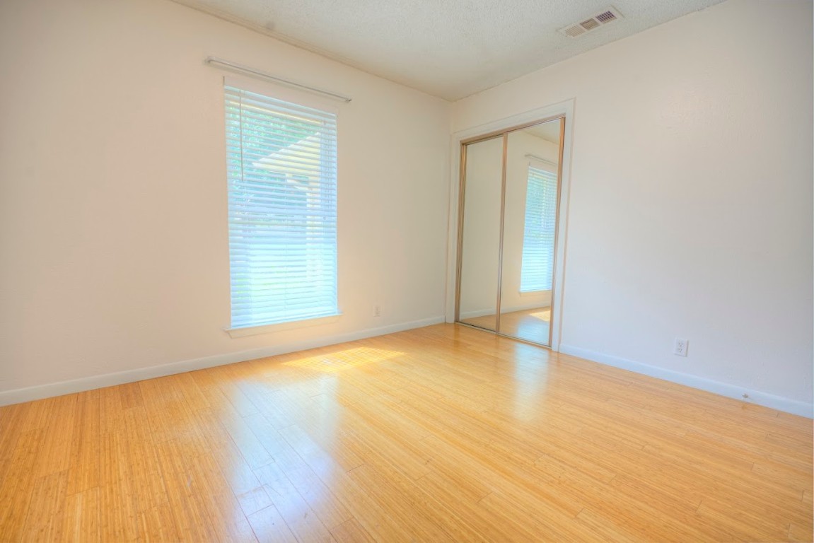7000 Greenock Street Austin, TX 78749 - Photo 16 of 22 an empty room with wooden floor and windows