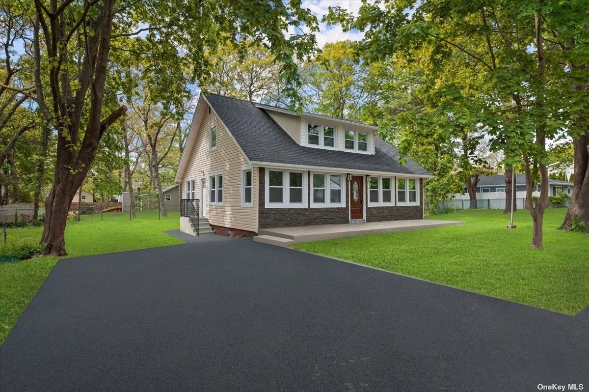 a view of a house with a big yard and large trees
