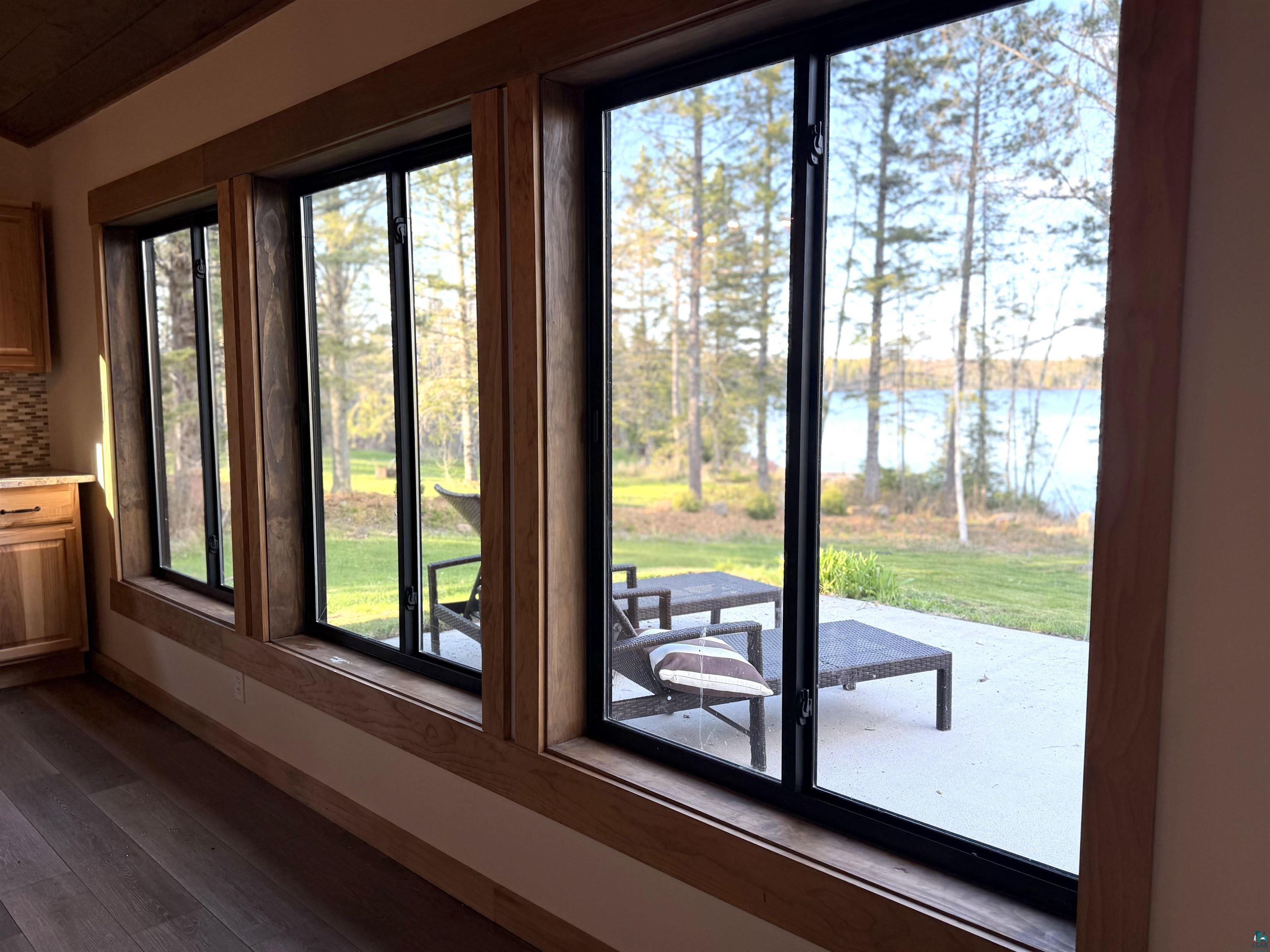 5274 Marble Lake Road Two Harbors, MN 55616 - Photo 14 of 79 Expansive window wall with natural wood trim framing serene water and tree views