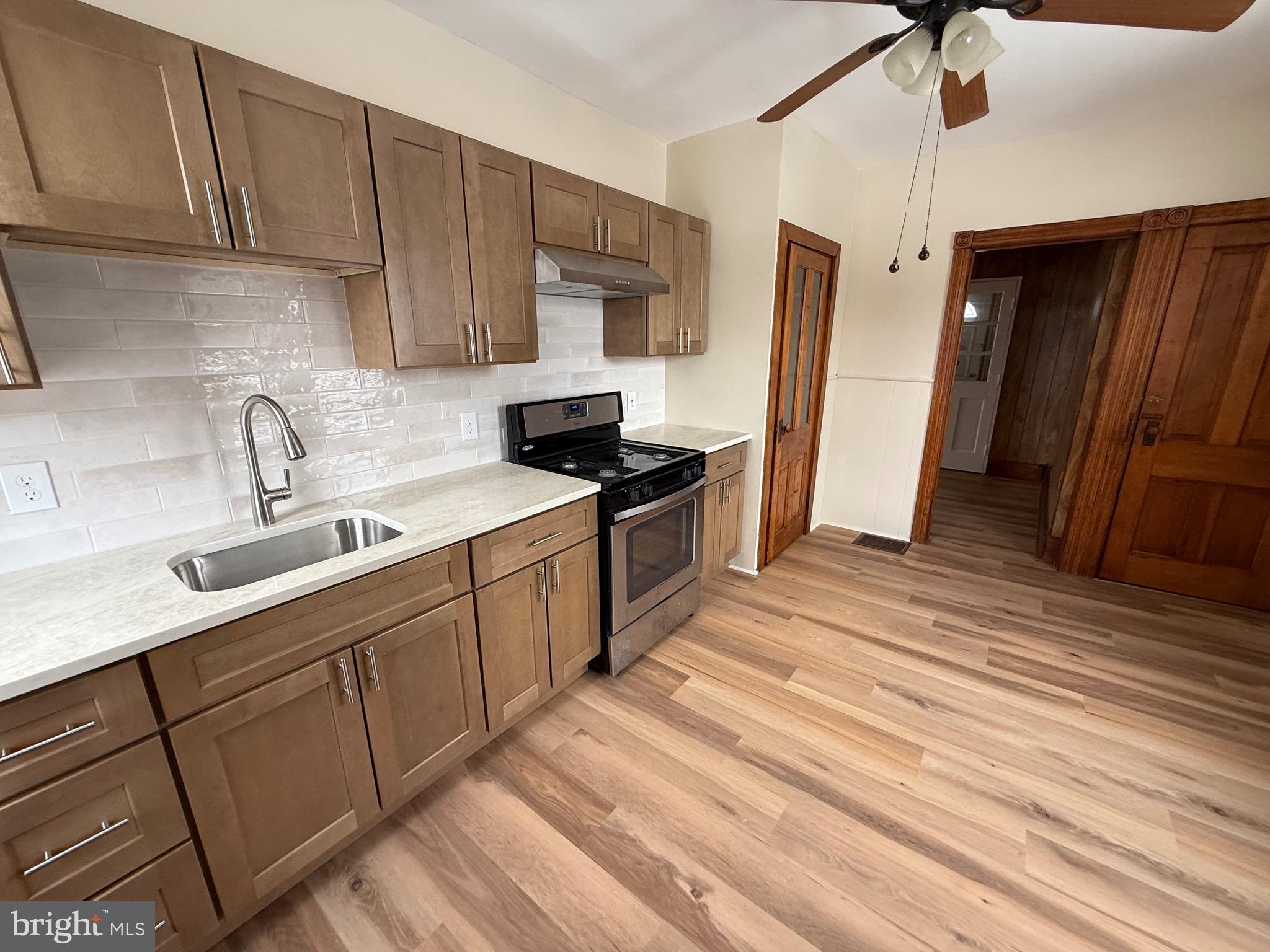 a kitchen with a sink a refrigerator and cabinets