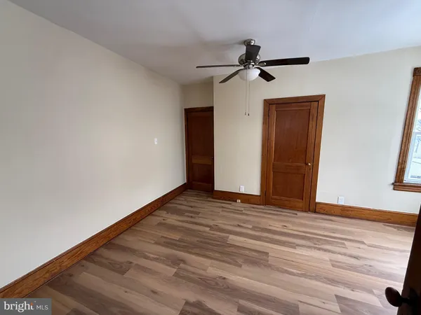 a view of a livingroom with wooden floor and a ceiling fan
