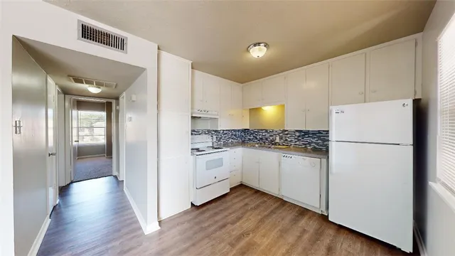 a kitchen with white cabinets and white appliances