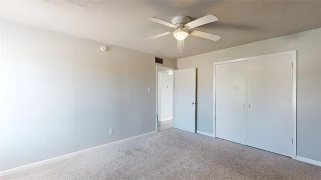 a view of an empty room with a chandelier fan