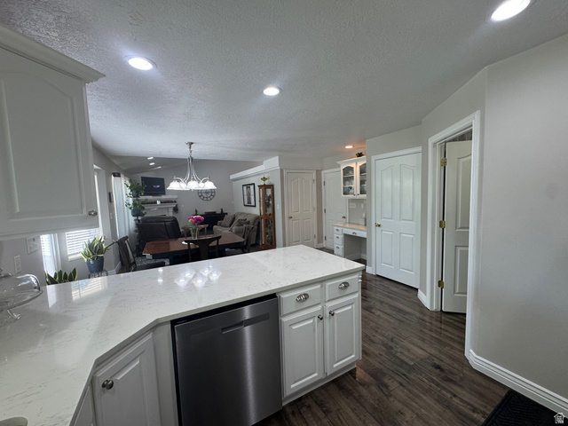 1976 River Bottom Road Springville, UT 84663 - Photo 12 of 45 Kitchen island featuring a light-toned countertop, white cabinetry with silver hardware, and an integrated stainless steel dishwasher