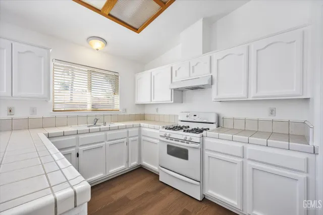 a kitchen with cabinets appliances a sink and a window