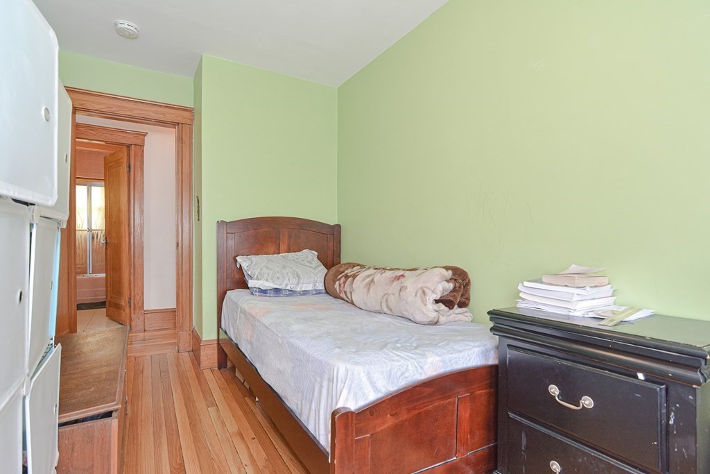 16 Rosedale Avenue Everett, MA 02149 - Photo 14 of 29 a bedroom with a bed and a lamp with wooden floor
