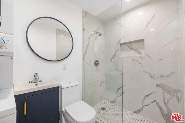 a bathroom with a toilet sink vanity and mirror