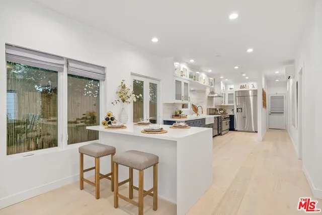 a large kitchen with a large window and stainless steel appliances