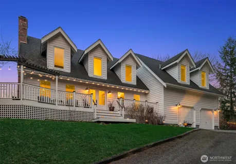 a view of a big house with a big yard and large trees