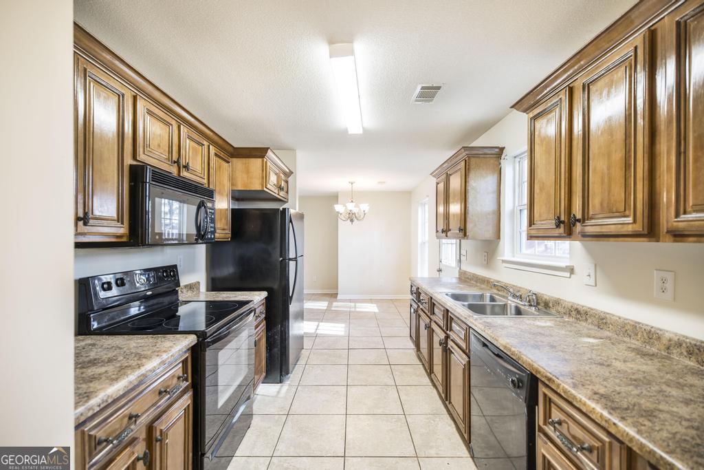 204 Chimney Rock Road Perry, GA 31069 - Photo 13 of 28 a large kitchen with stainless steel appliances granite countertop a stove top oven a refrigerator a sink and dishwasher