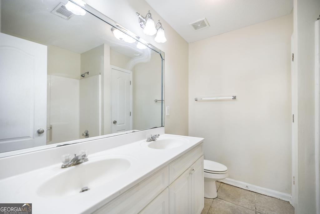 204 Chimney Rock Road Perry, GA 31069 - Photo 17 of 28 a bathroom with a toilet a sink and mirror