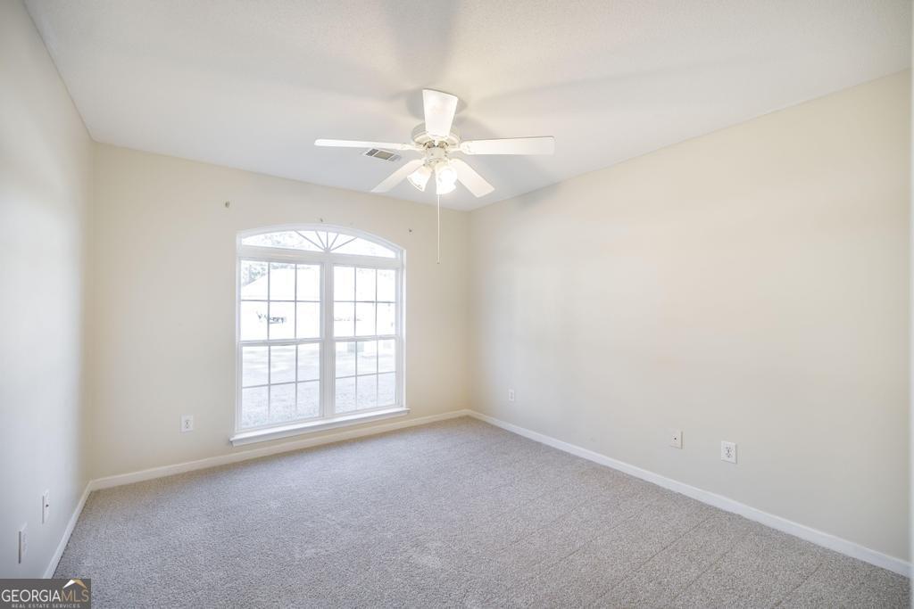204 Chimney Rock Road Perry, GA 31069 - Photo 23 of 28 an empty room with windows and ceiling fan