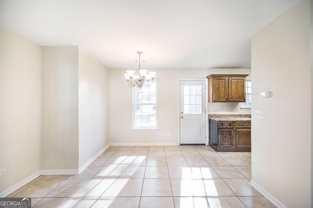204 Chimney Rock Road Perry, GA 31069 - Photo 9 of 28 an empty room with a fireplace and windows