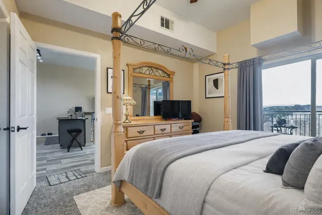 a bedroom with a large bed a flat screen tv and a fireplace