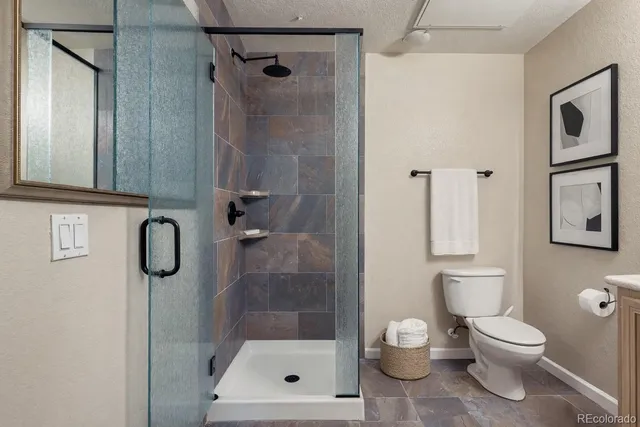 a bathroom with a toilet and a shower