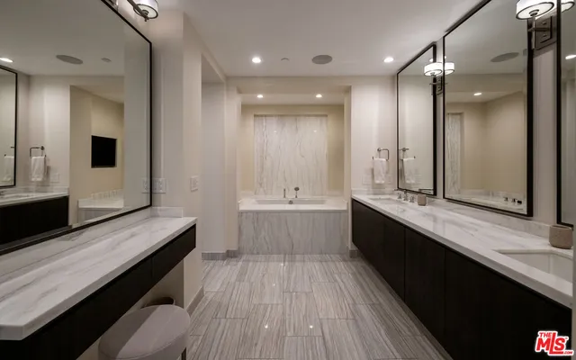 a bathroom with a sink a large mirror and a shower