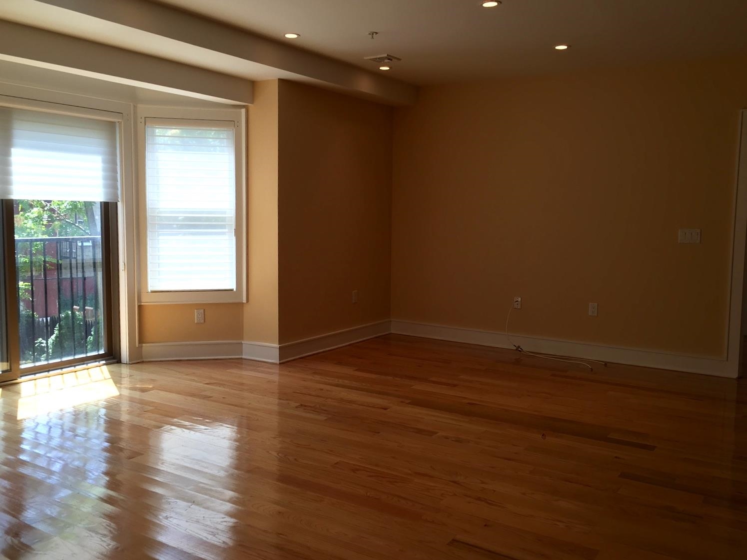 123 Jackson Street, Unit 2B Hoboken, NJ 07030 - Photo 3 of 13 a view of an empty room with wooden floor and a window