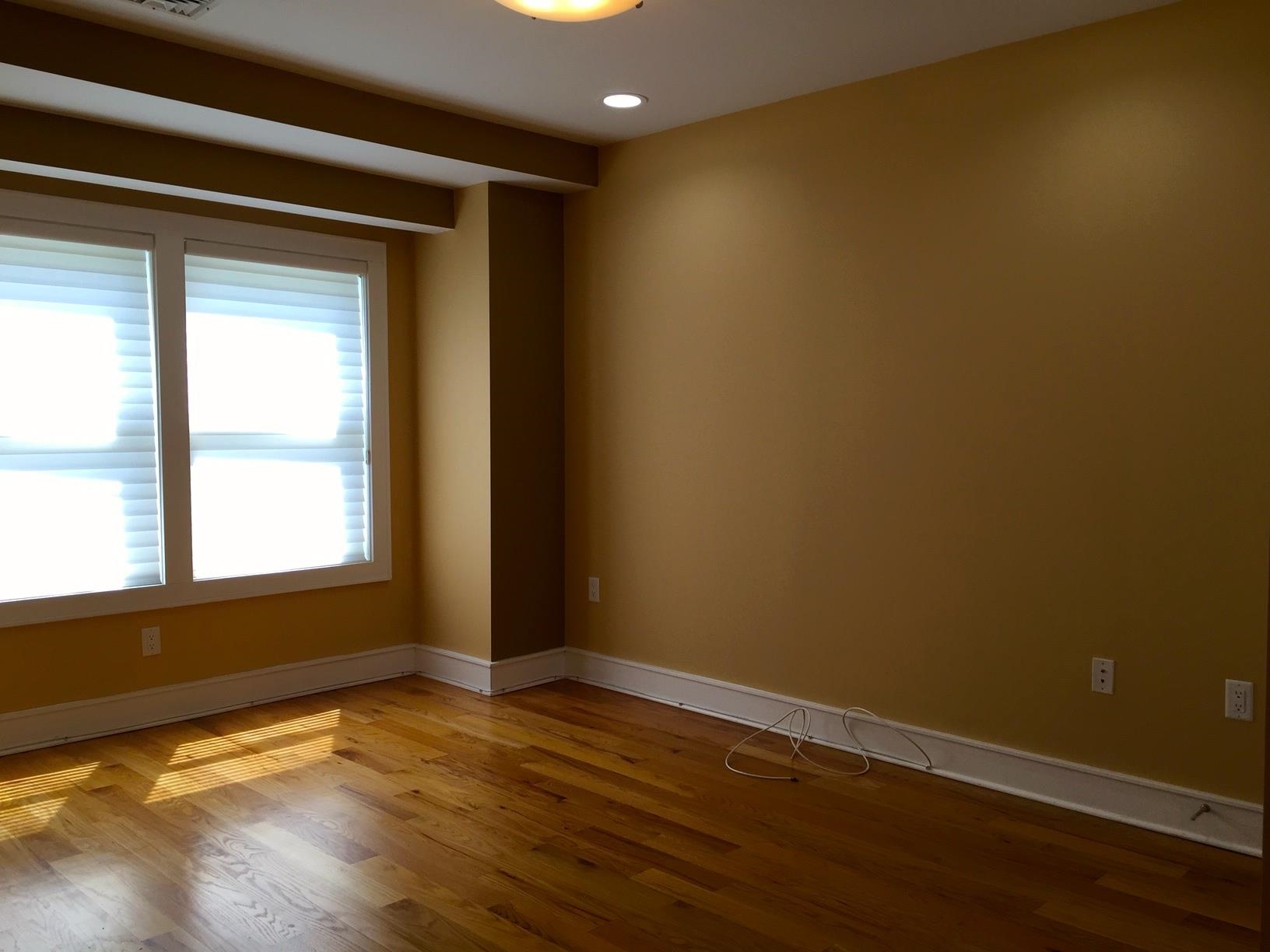 123 Jackson Street, Unit 2B Hoboken, NJ 07030 - Photo 7 of 13 an empty room with wooden floor and windows