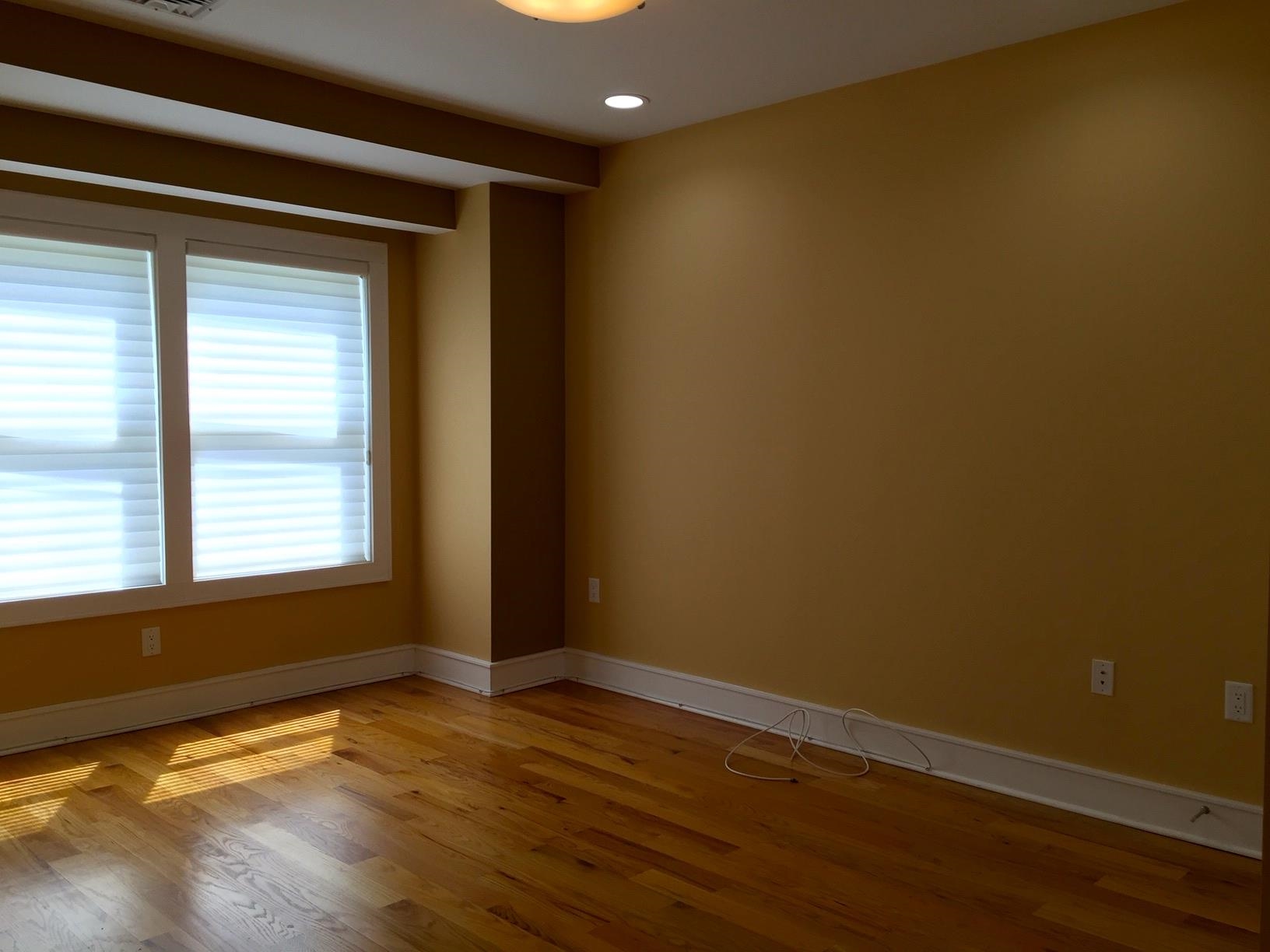 123 Jackson Street, Unit 2B Hoboken, NJ 07030 - Photo 8 of 13 an empty room with wooden floor and windows