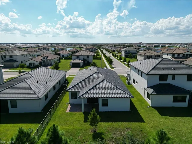 an aerial view of multiple houses with a yard