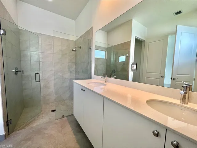 a bathroom with a shower sink and mirror