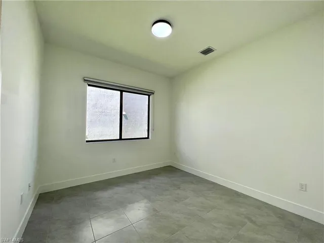 an empty room with a fan and window