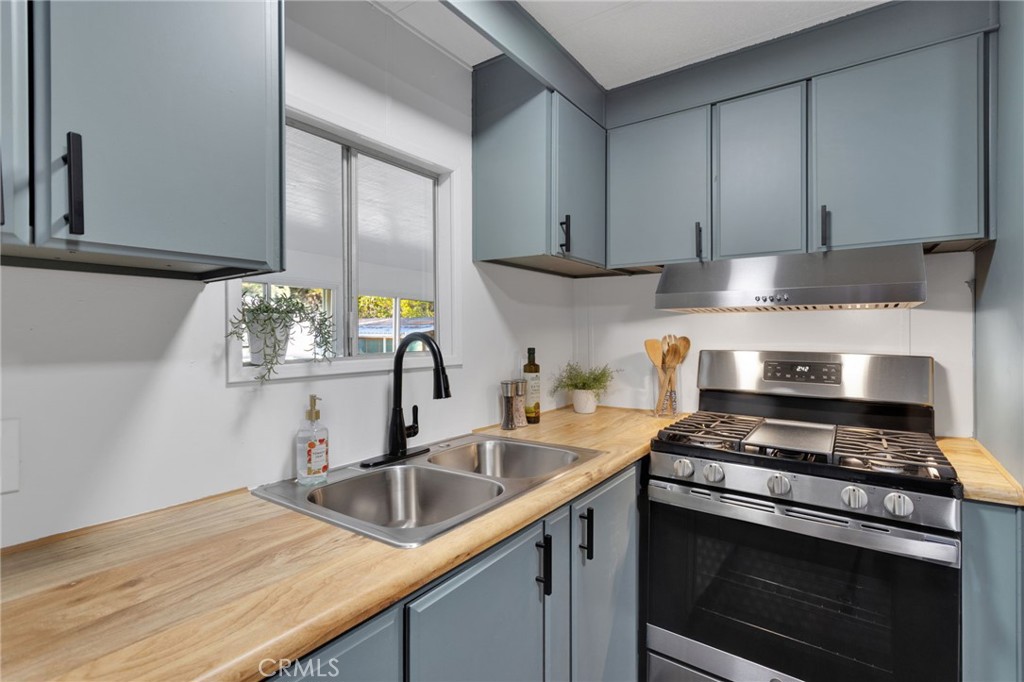 a kitchen with stainless steel appliances granite countertop a sink stove and cabinets